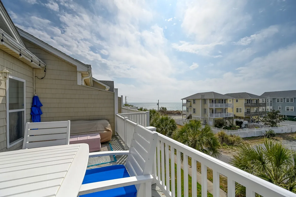 A scenic sun deck with comfortable deck furniture, palm trees in the background, and a breathtaking view of the Atlantic Ocean. The setting is perfect for sunset drinks, relaxation, and soaking up coastal beauty.