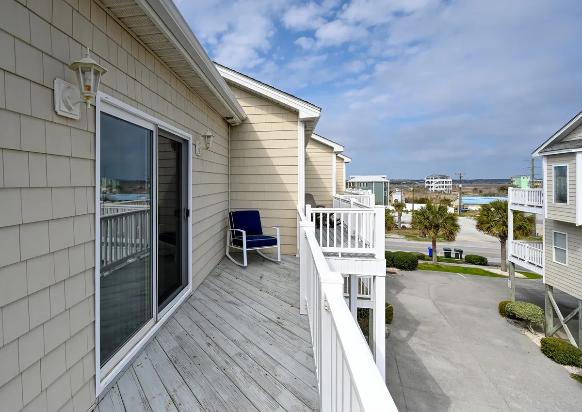 A tranquil private balcony with a blue chair overlooking surrounding buildings and landscape, ideal for soaking up morning tranquility or enjoying an evening breeze. The space suggests privacy and a connection with the outdoors.