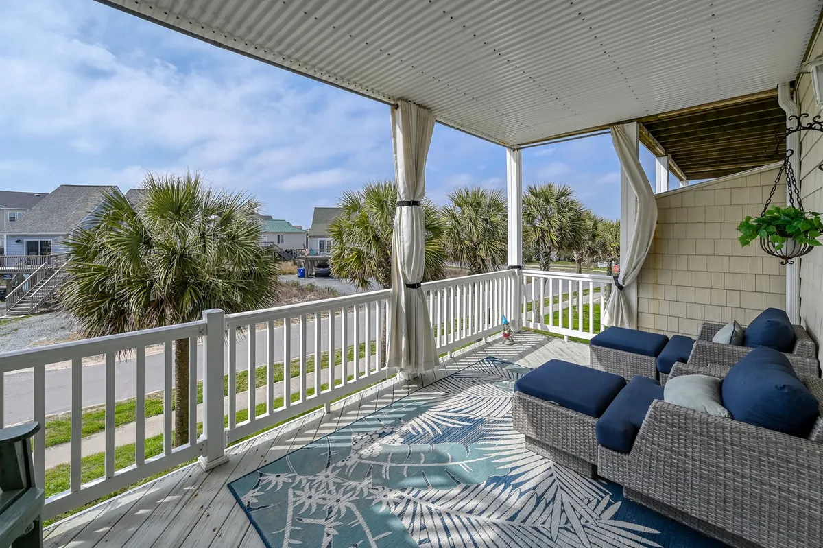 An inviting exterior seating area surrounded by palm trees, featuring comfortable chairs and a decorative rug. The setting suggests both shaded comfort and open-air enjoyment, ideal for socializing, relaxing with a morning coffee, or enjoying evening conversations under the stars.